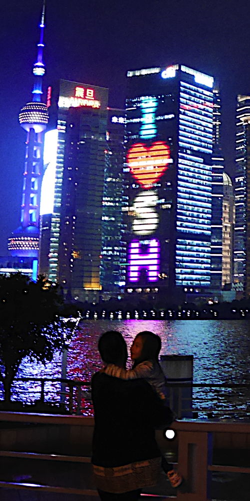 A father and daughter take in the lights of Shanghai