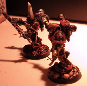 Two black and red chaos space marines
