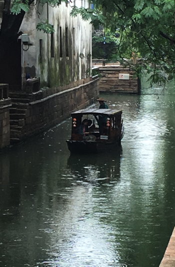 Small boat travelling on the canals of Suzhou China